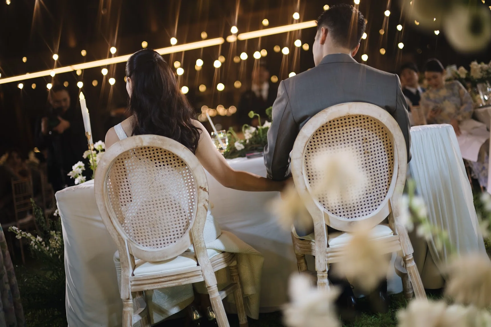 Couple seated at the outdoor reception at the Annie & Louis celebration in Bangkok