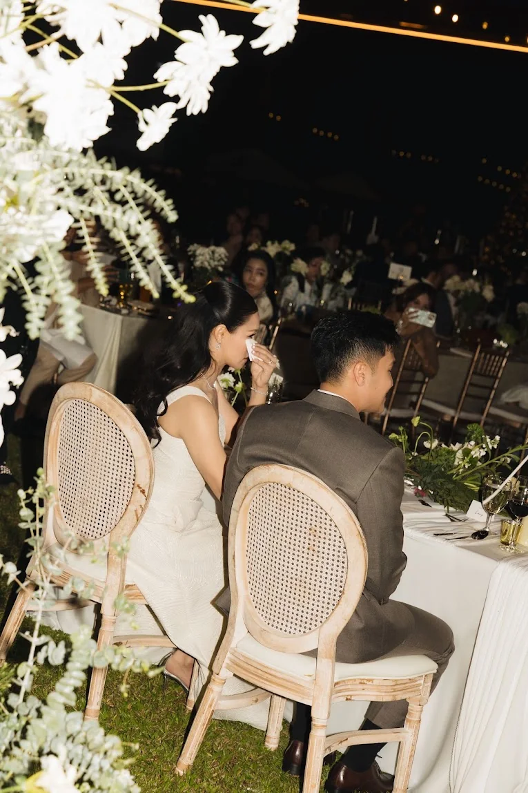 Couple seated among the ceremony guests at the Annie & Louis celebration in Bangkok