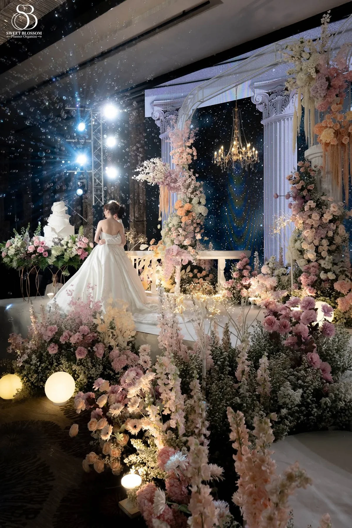 Pastel floral wedding stage with candlelight at the Orm & Fuse celebration in Bangkok