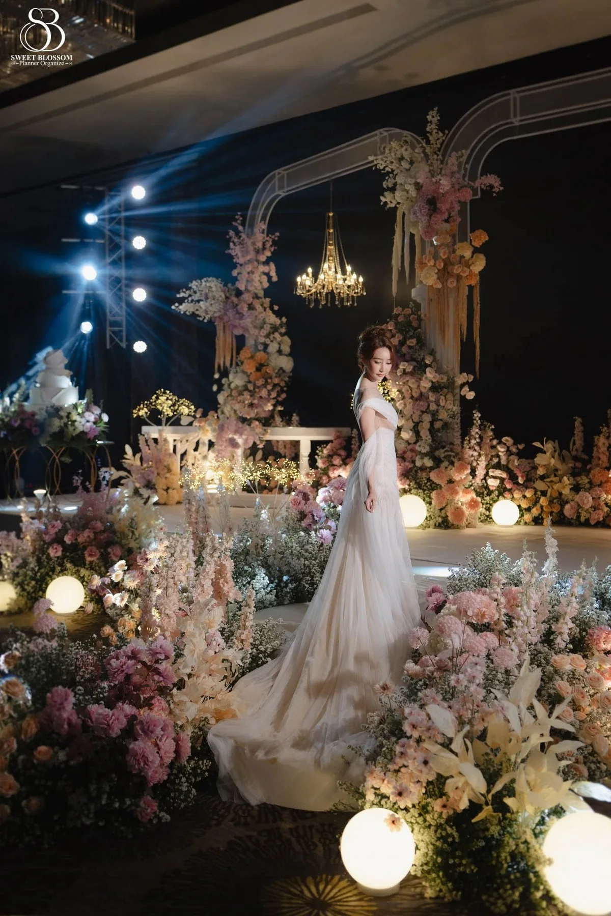 Bride standing on the pastel floral stage at the Orm & Fuse celebration in Bangkok