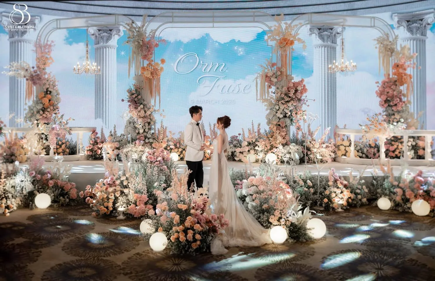 Couple on the illuminated pastel wedding stage at the Orm & Fuse celebration in Bangkok