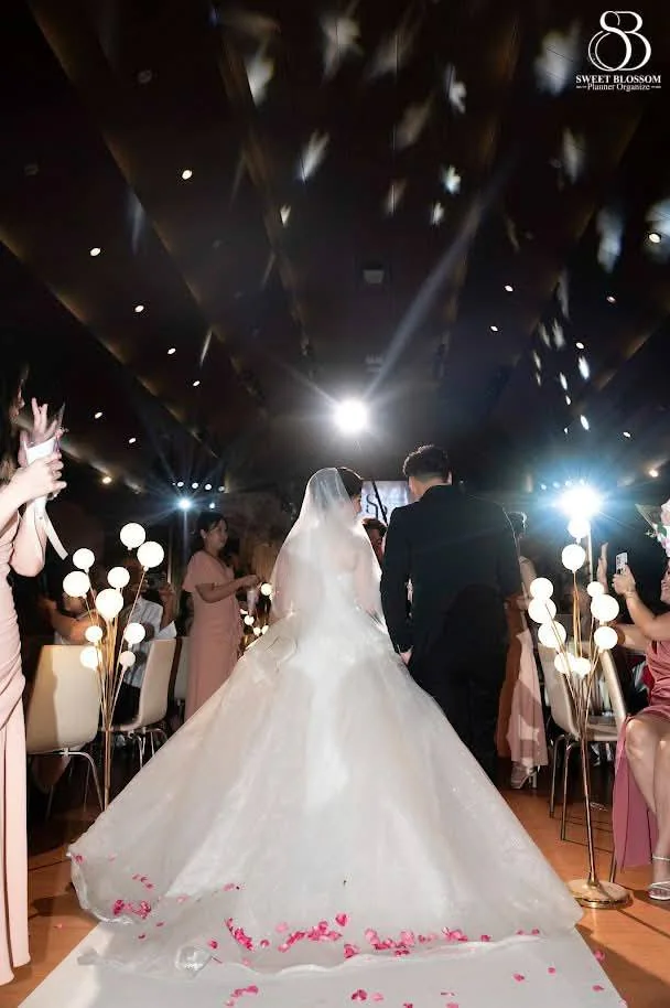 Couple entering through the sparkler-lit guest aisle at the Foam & Petch celebration in Lopburi