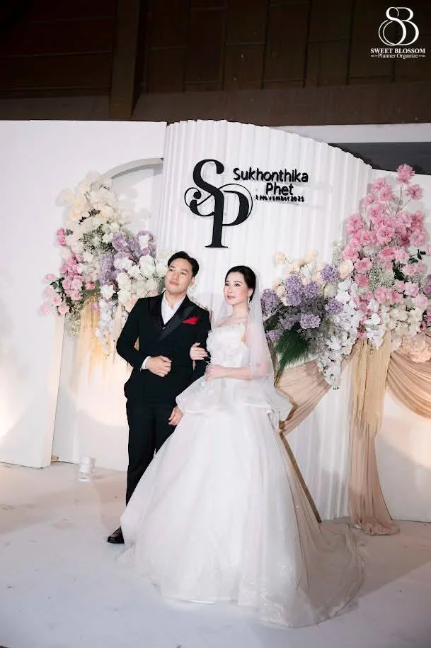 Couple portrait at the pastel floral backdrop at the Foam & Petch celebration in Lopburi