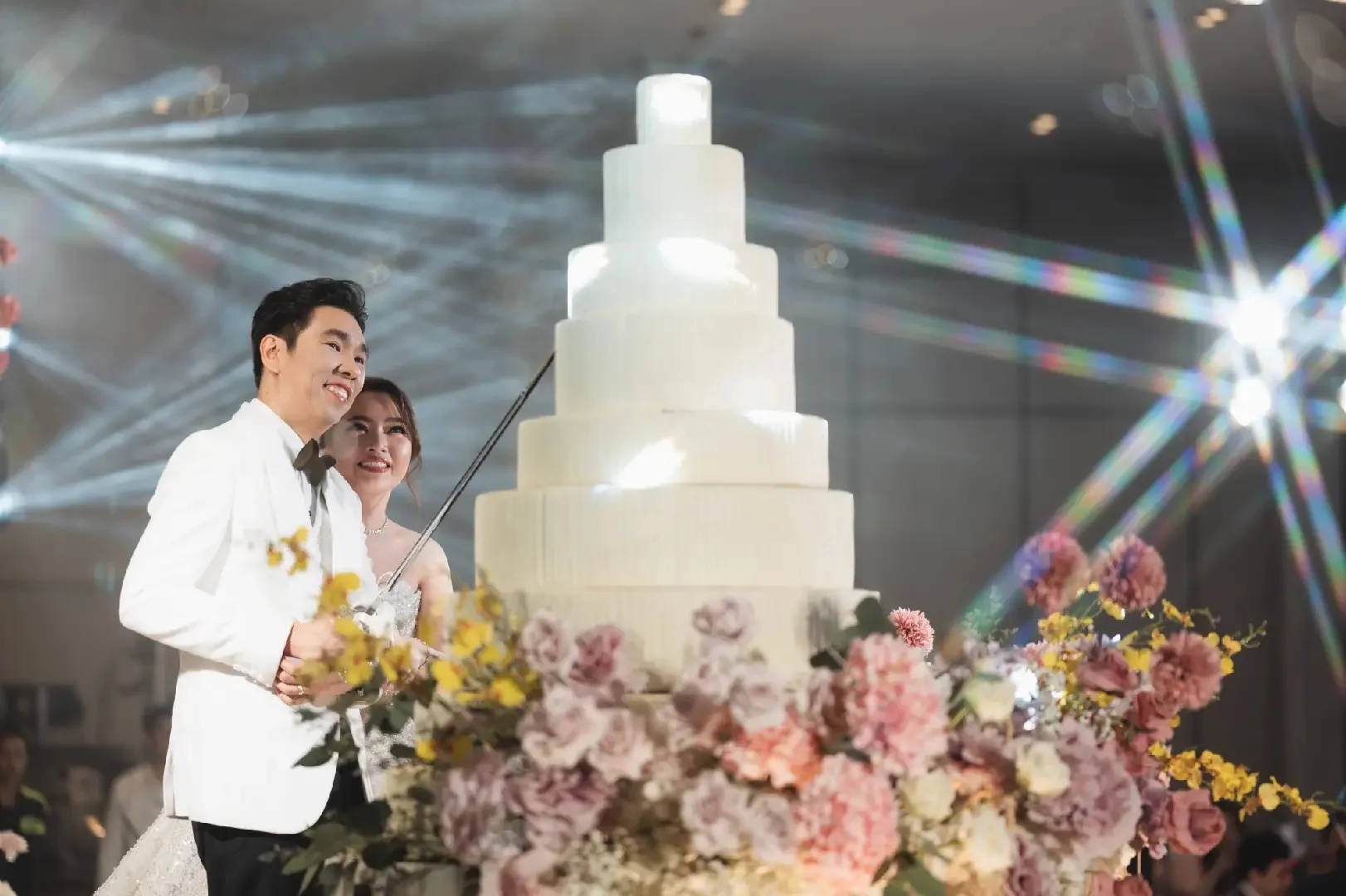 Couple preparing to cut the wedding cake at the Jum & Jai celebration in Chonburi