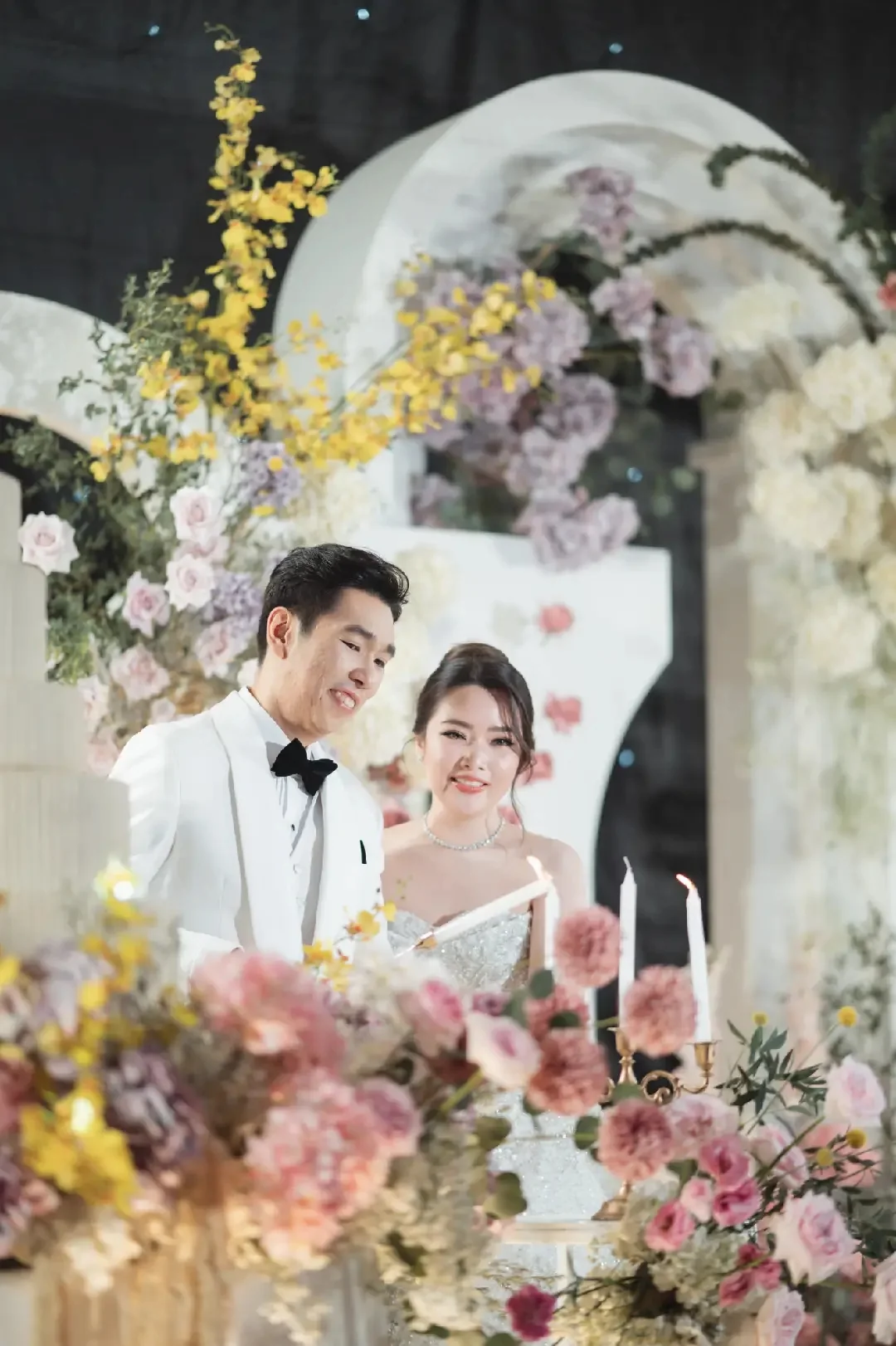 Couple portrait beside the wedding cake at the Jum & Jai celebration in Chonburi