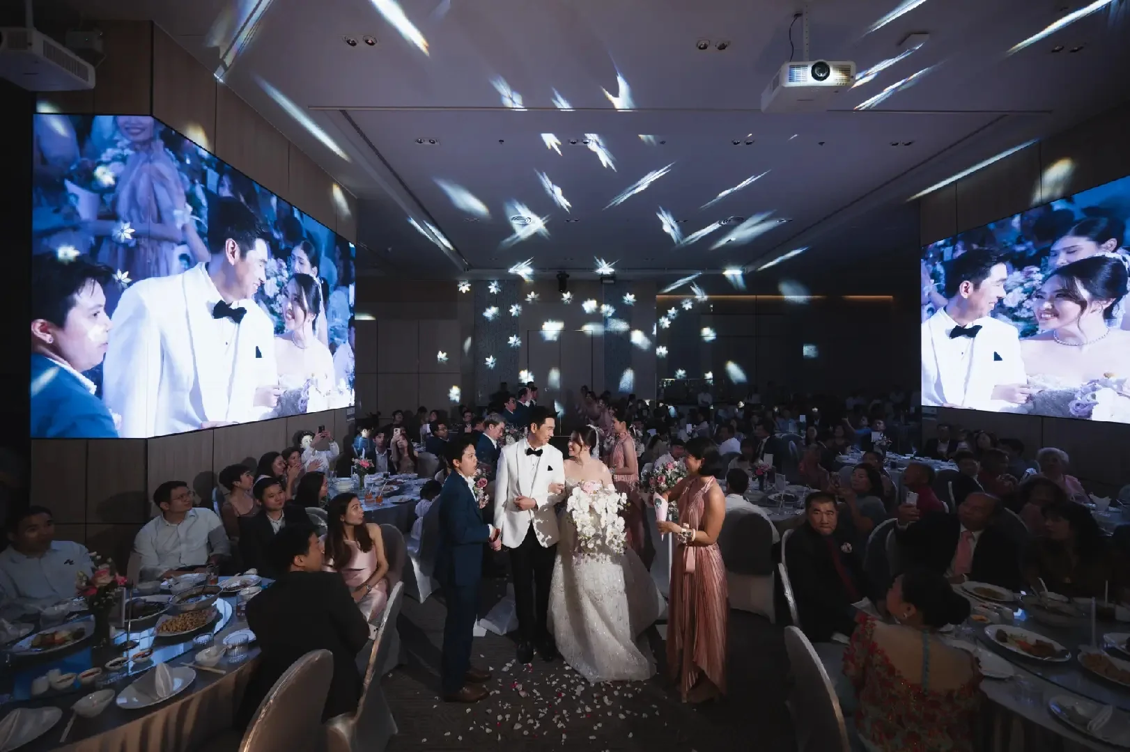 Couple celebrating with guests in the ballroom at the Jum & Jai celebration in Chonburi