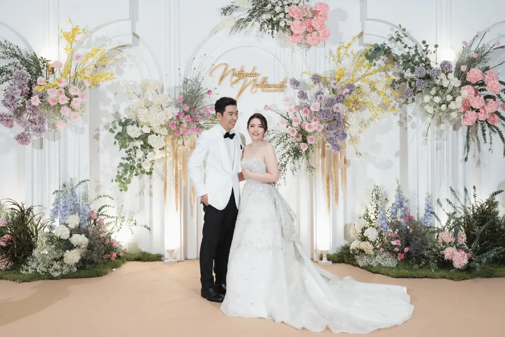 Full portrait of the couple at the pastel floral stage at the Jum & Jai celebration in Chonburi