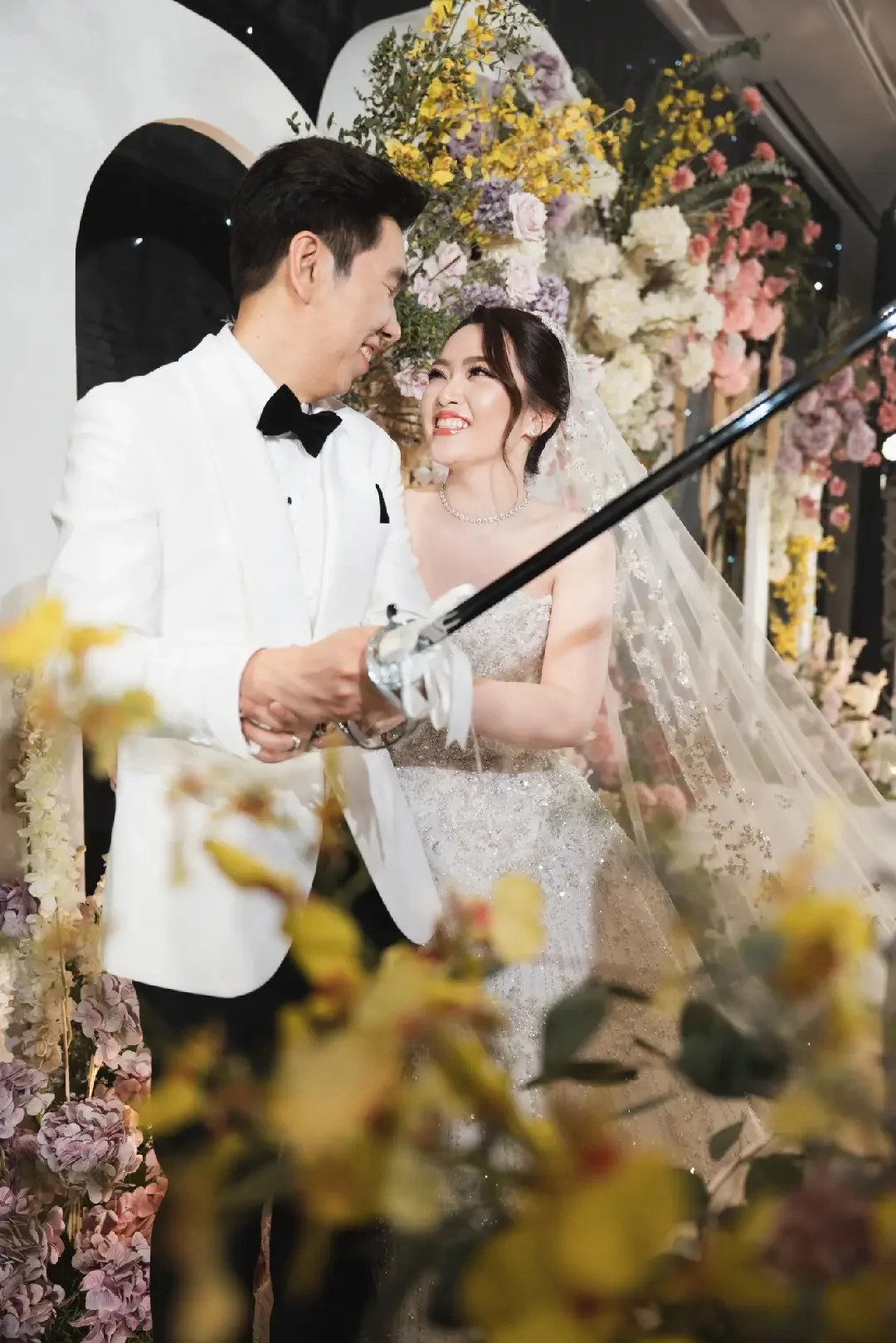 Close portrait of the couple behind flowers at the Jum & Jai celebration in Chonburi