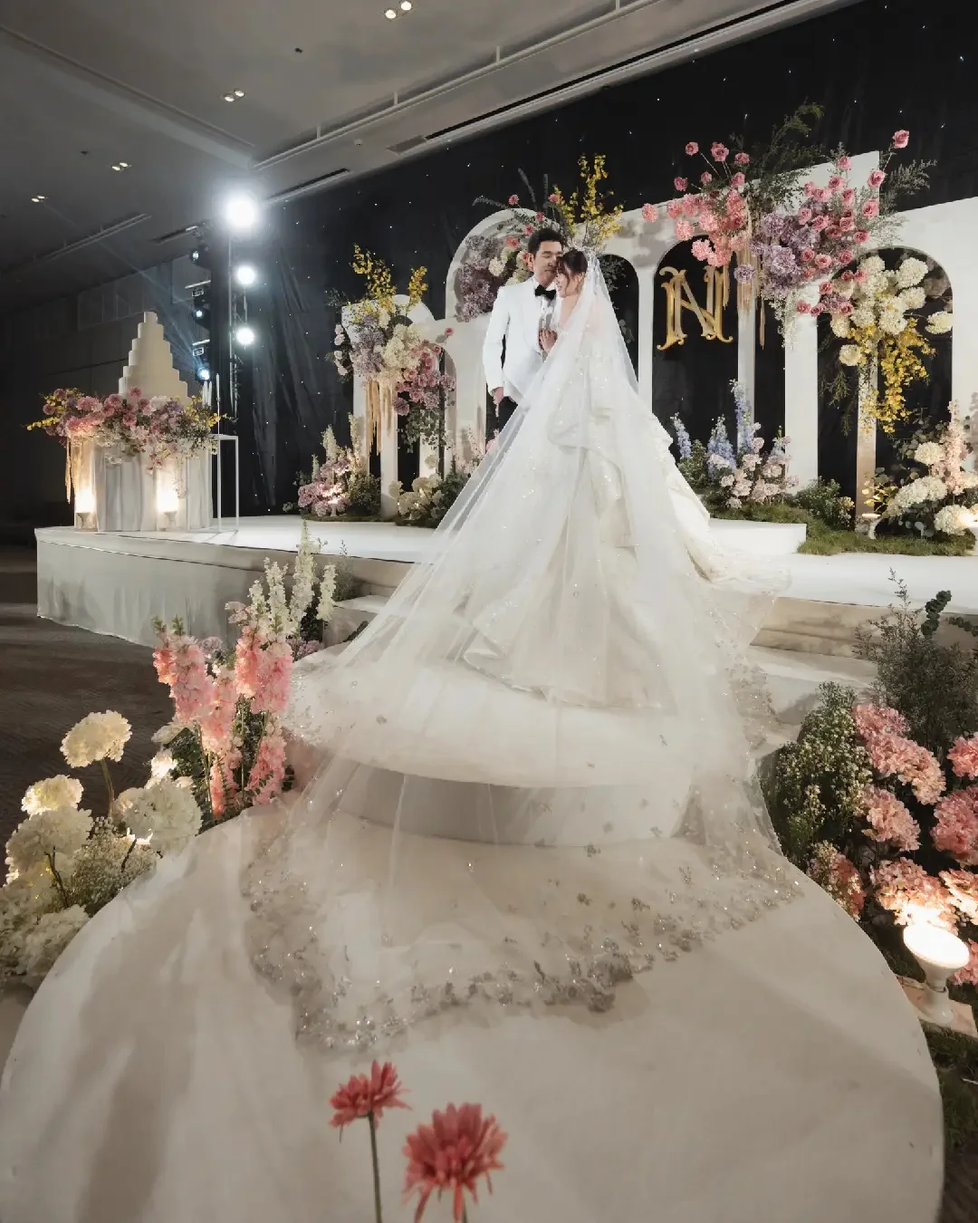 Bride walking across the floral stage at the Jum & Jai celebration in Chonburi