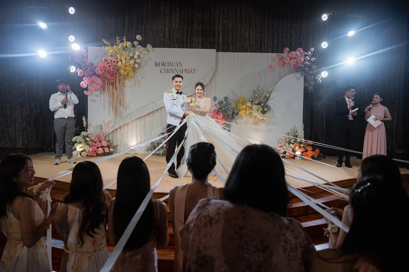 Couple standing on the reception stage at the Koko & Raam celebration in Chonburi
