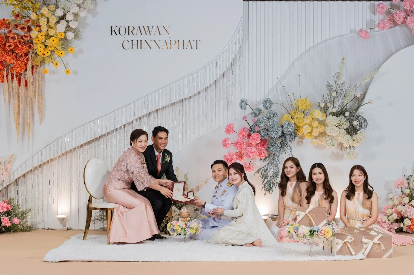 Family group portrait at the wedding stage at the Koko & Raam celebration in Chonburi