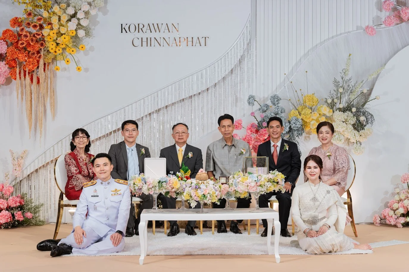 Extended family portrait at the wedding stage at the Koko & Raam celebration in Chonburi