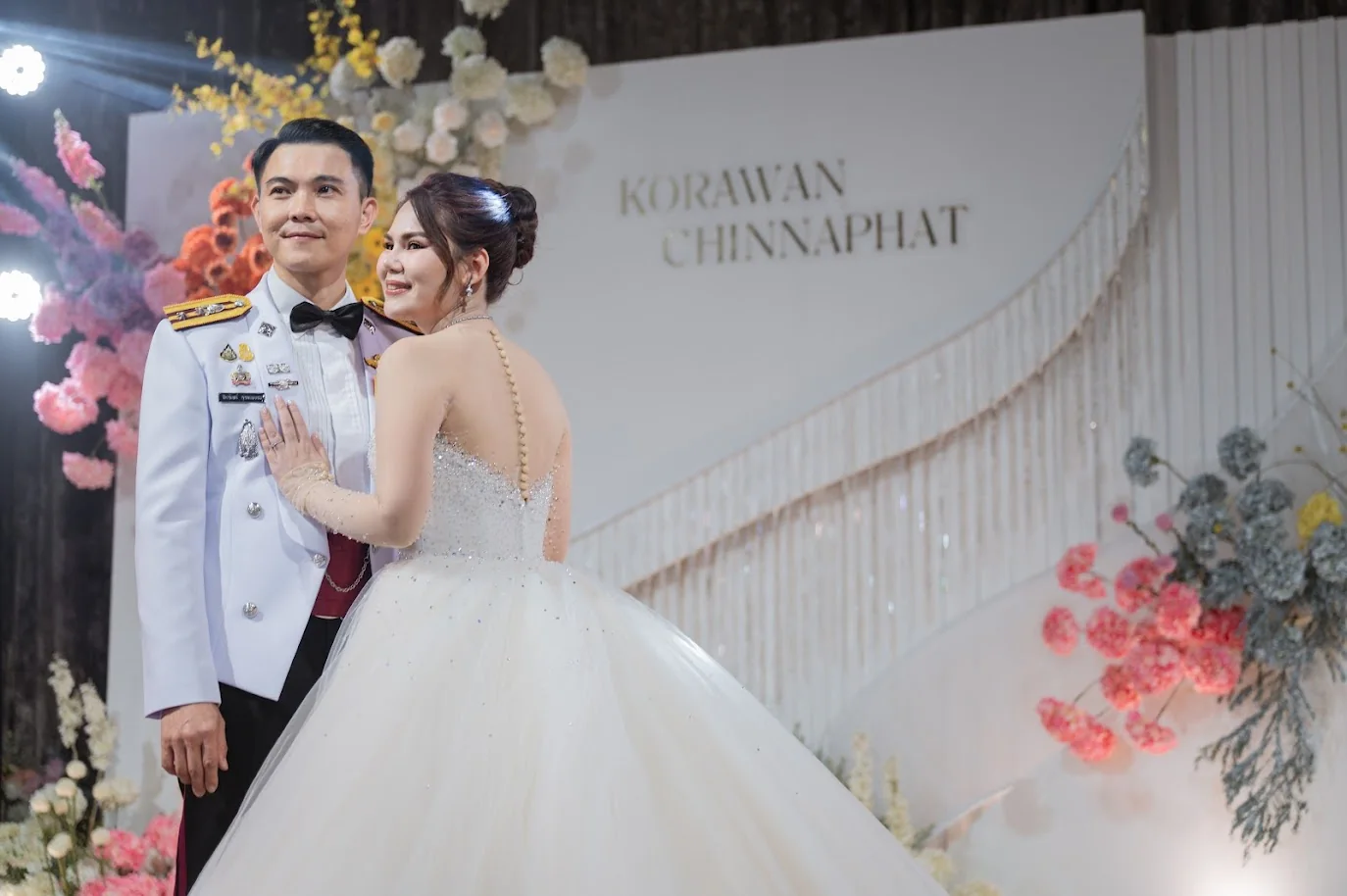 Close portrait of the couple at the floral stage at the Koko & Raam celebration in Chonburi