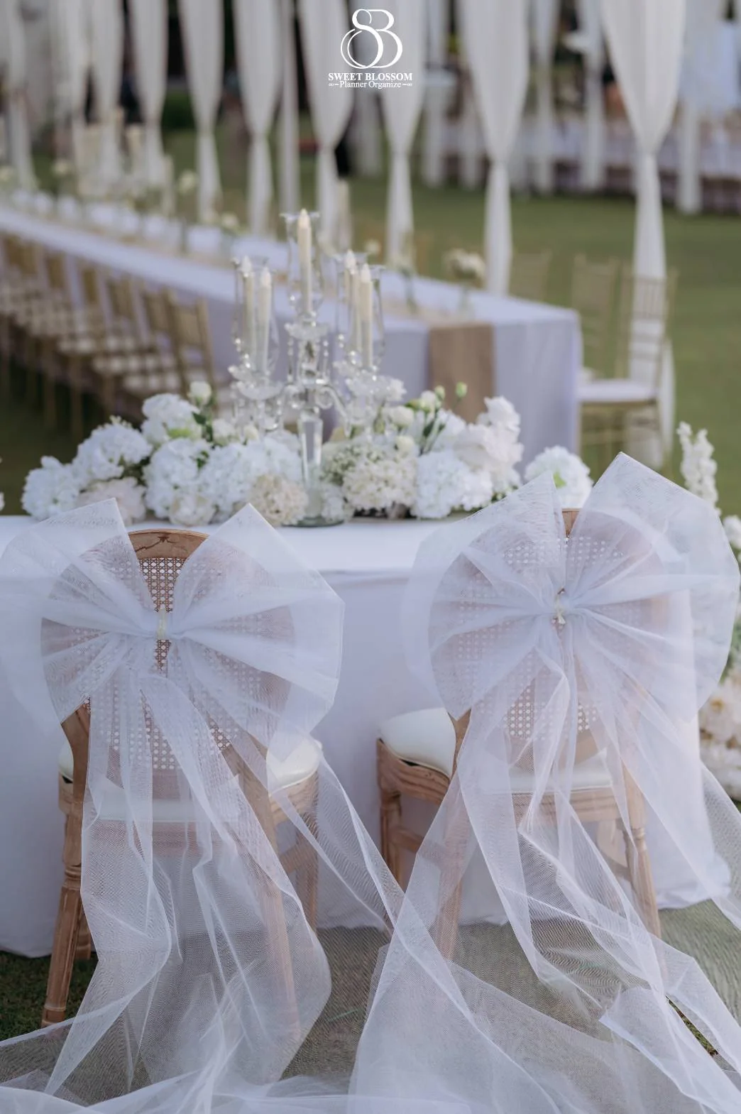White reception table setting with soft draping at the Mook — Christmas Wedding celebration in Lopburi