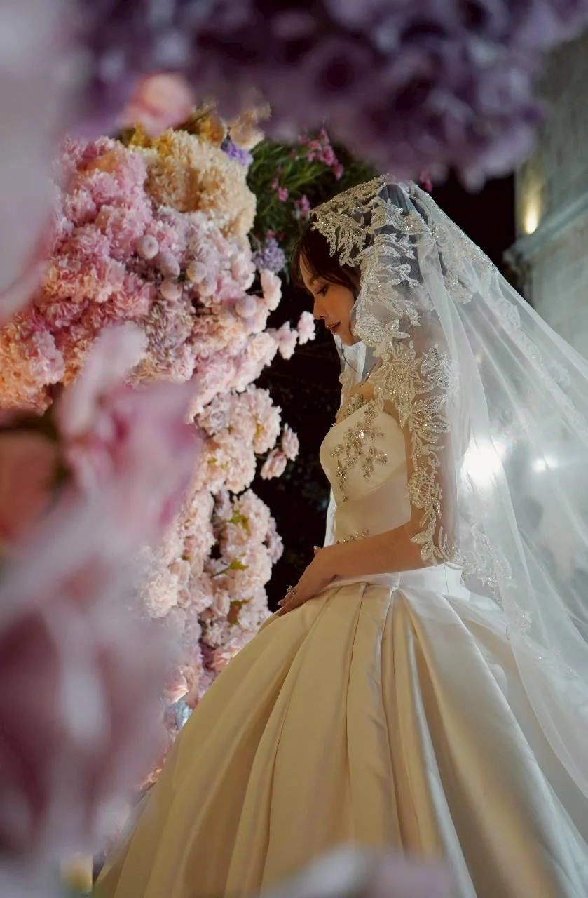 Bride framed by pastel flowers at the Nan & Big celebration in Bangkok