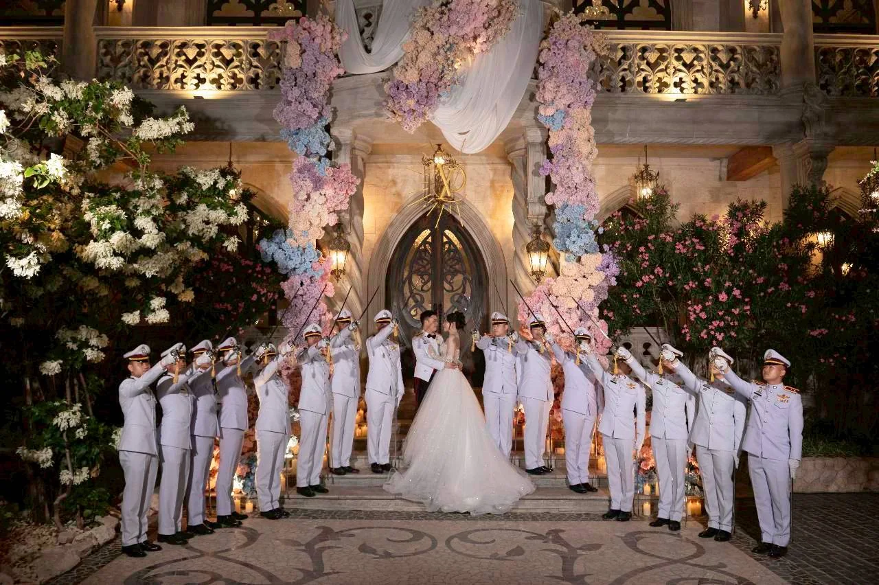 Couple with the ceremonial honour guard outside the chapel at the Nan & Big celebration in Bangkok