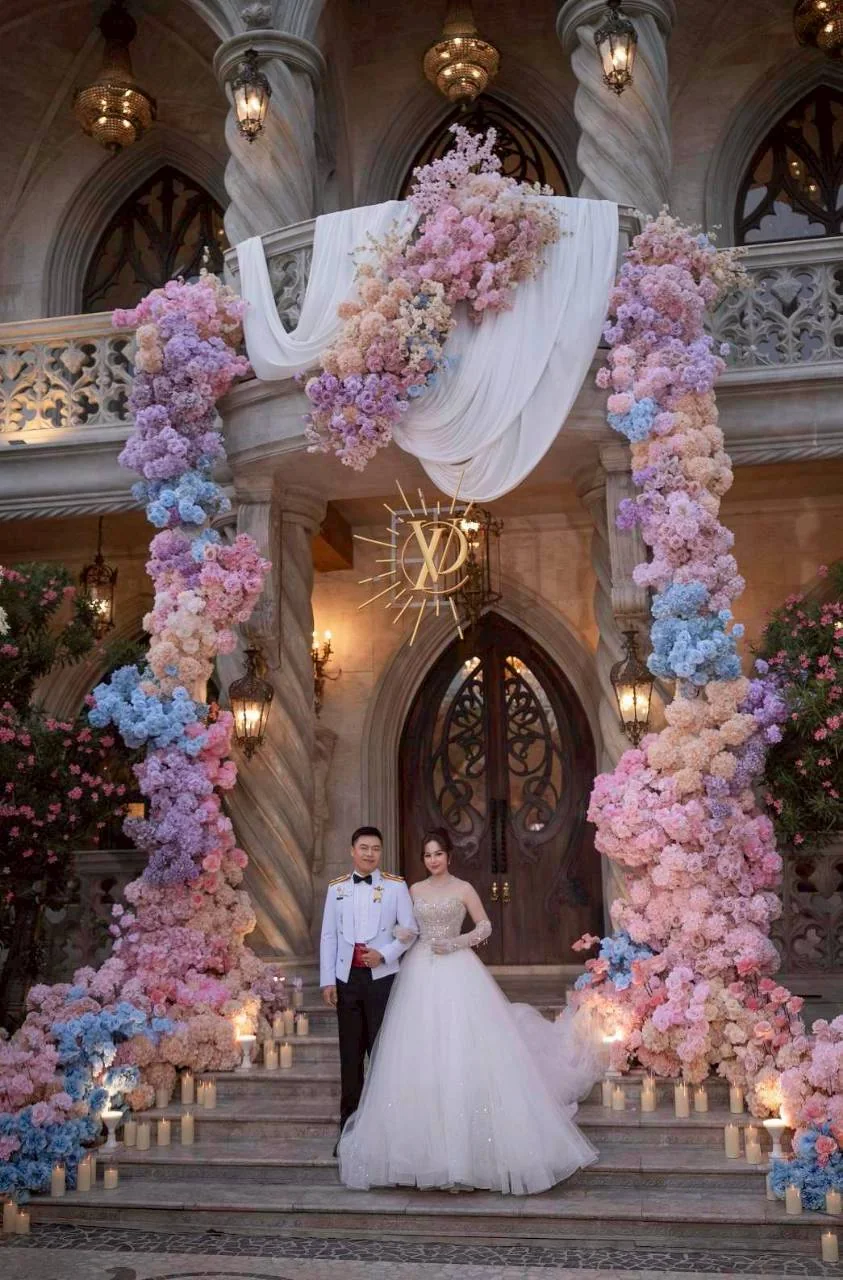 Couple at the flower-covered chapel entrance at the Nan & Big celebration in Bangkok