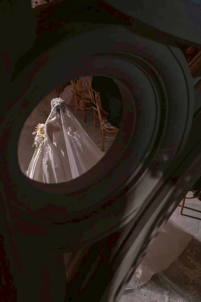Bride viewed through the spiral staircase at the Nan & Big celebration in Bangkok
