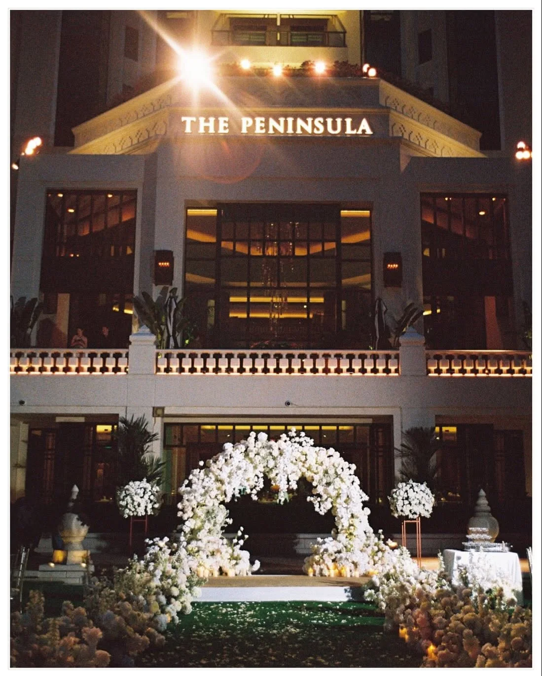 The Peninsula facade and white floral ceremony stage at the Natt & Yang celebration in Bangkok