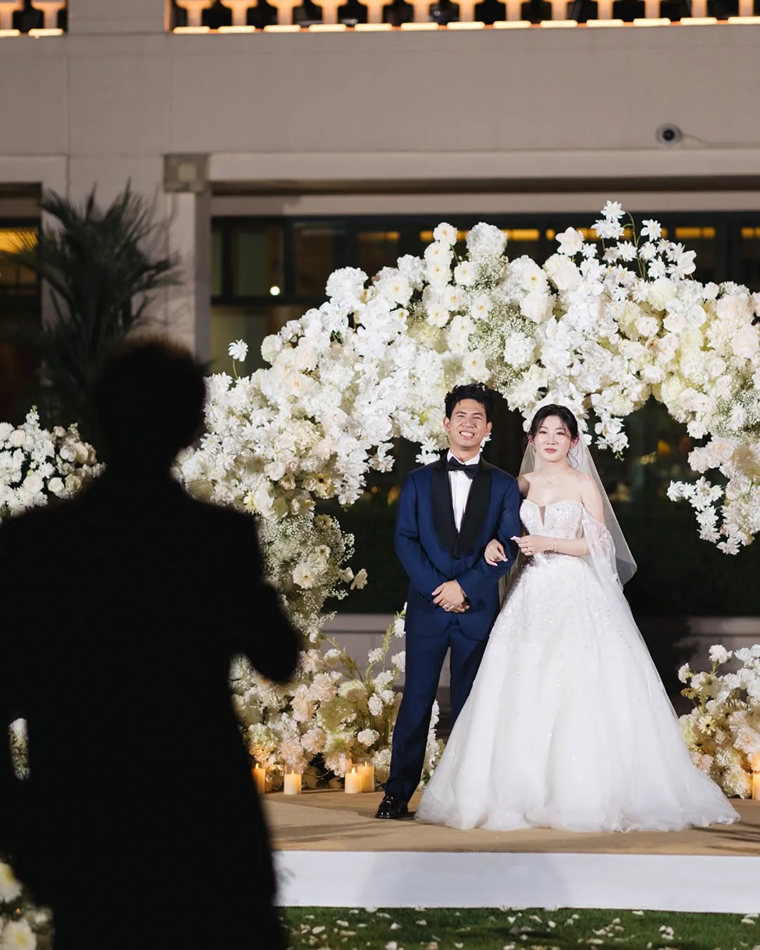 Couple portrait at the white floral stage at the Natt & Yang celebration in Bangkok