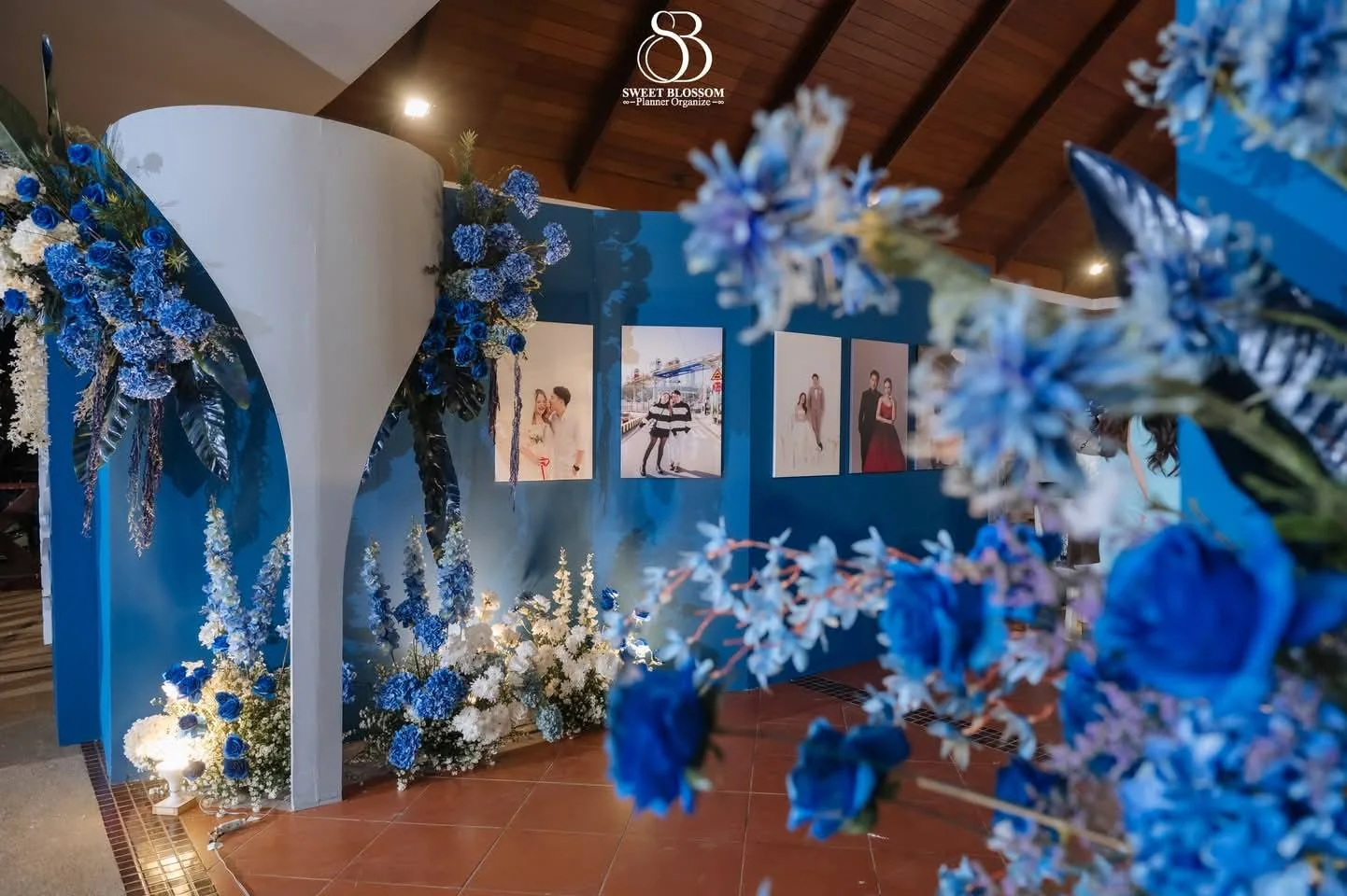Blue floral welcome and photo display at the Yam & Ball celebration in Lopburi