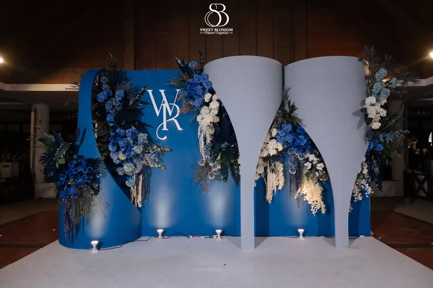Blue floral ceremony backdrop at the Yam & Ball celebration in Lopburi